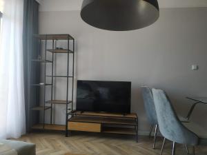 sala de estar con TV de pantalla plana y 2 sillas azules en Romance Paris B502, en Sveti Vlas