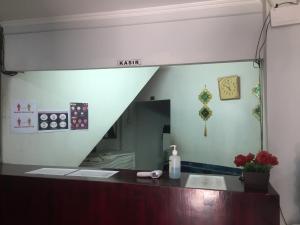 a mirror above a sink in a bathroom at Losmen PUM Syariah at Desa Wisata Sabang in Sabong