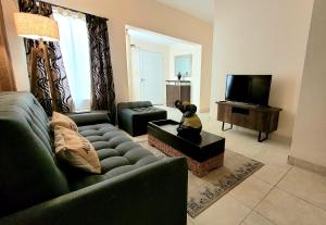 sala de estar con sofá y TV en Victorino House en el Cerro de las Rosas con cochera en Córdoba