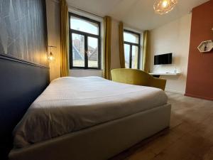 1 dormitorio con 1 cama con silla y ventana en Cosy studio lumineux Metz hypercentre, en Metz