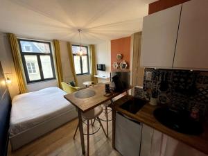 1 dormitorio con 1 cama y cocina con escritorio en Cosy studio lumineux Metz hypercentre, en Metz