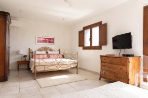 um quarto com uma cama, uma televisão e uma cómoda em Mas Montbrio Belvedere em Cambrils