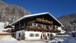 ein großes Gebäude mit Schnee auf dem Dach in der Unterkunft Pension Etzerschlössl in Berchtesgaden