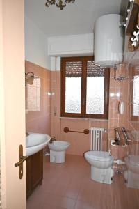 y baño con 2 aseos, lavamanos y bañera. en Bardonecchia Appartamento XL en Bardonecchia