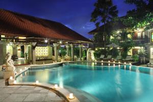 una piscina en un hotel por la noche en Adhi Jaya Hotel, en Kuta