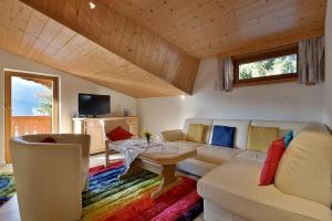 een woonkamer met een bank en een tafel bij Haus am Waldesrand in Ellmau