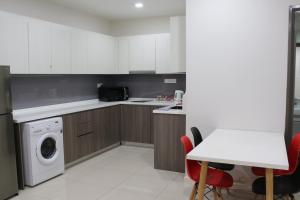 una cocina con lavadora y mesa en Suasana Suites D'homestay JB Town, en Johor Bahru