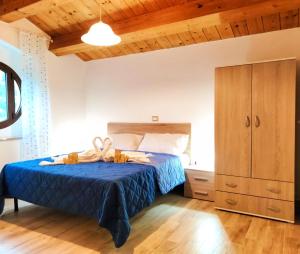 a bedroom with a blue bed and a cabinet at IL VILLAGGIO DELLE FATE in Macerata
