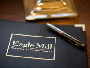 un bolígrafo sentado encima de un cuaderno en una mesa en Eagle Mill Luxury Rooms en Huntingdon