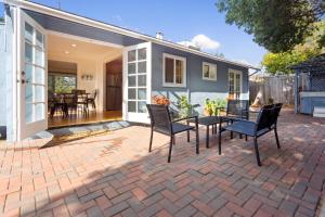 una casa y un patio con mesa y sillas en @ Marbella Lane - 3BR Belmont Cozy House en Belmont