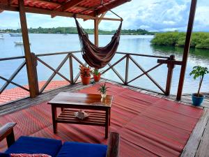 a hammock on a deck with a view of the water at The Sunsetter Bed & Breakfast in Bocas del Toro