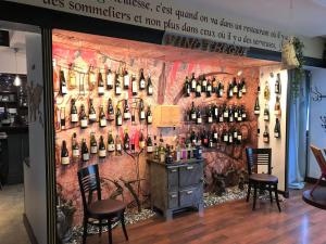 a room with a bunch of wine bottles on a wall at L'Auberg'ine - Maison Glenn Anna in Sainte Anne d'Auray