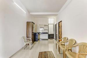 a living room with chairs and a table and a kitchen at Neelkanth Homes in Garudeshwar