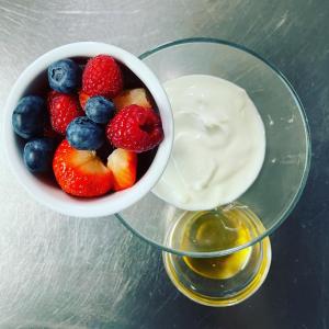 a bowl of fruit next to a bowl of yogurt at Ouse Bridge House in Bassenthwaite Lake +30 photos