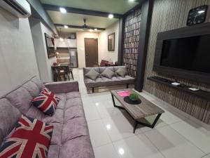 uma sala de estar com sofás e uma grande televisão em Ipoh Premium Homestay @ Majestic em Ipoh