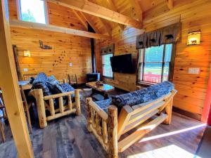 a log cabin living room with couches and a tv at BC Log cabin with private beach river fire pit AC wifi onsite trails ski slope views in Carroll