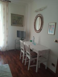 ein Esszimmer mit einem Tisch, Stühlen und einem TV in der Unterkunft B&B le Villette Predappio in Predappio