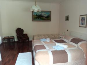 ein Schlafzimmer mit 2 Betten in einem Zimmer mit einem Sofa in der Unterkunft B&B le Villette Predappio in Predappio