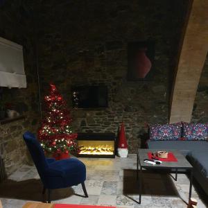 un soggiorno con un albero di Natale e un camino di Petradaki House a Arakapas