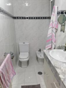 a white bathroom with a toilet and a sink at PISO EN PLENO CENTRO DE MIÑO in Miño