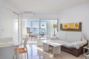 a living room with a white couch and a table at Penthouse studio with sea views in La Cala de Mijas