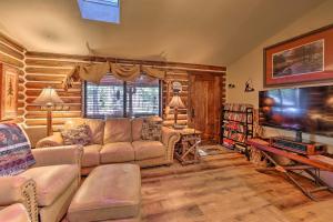 ein Wohnzimmer mit einem Sofa und einem Flachbild-TV in der Unterkunft Rustic Lakeside Cabin - Family and Pet Friendly! in Pinetop-Lakeside