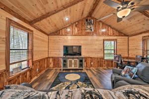 a living room with a couch and a tv at Cozy Broken Bow Cabin, Walk to the Lukfata Creek! in Broken Bow