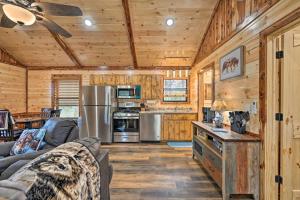 a living room with a couch and a kitchen at Cozy Broken Bow Cabin, Walk to the Lukfata Creek! in Broken Bow