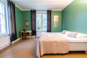 a bedroom with a bed with green walls and a table at Haapala Brewery restaurant and accommodation in Vuokatti