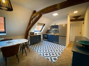Le KT-Dral - Appartement hypercentre في بورج: مطبخ مع دواليب زرقاء وطاولة وكراسي