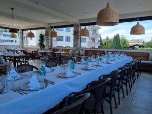 een lange tafel in een restaurant met tafels en stoelen bij Hiša Ančka, Šenčur in Šenčur