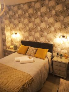1 dormitorio con 1 cama y una pared con flores en Hipica Home Granada Center en Granada