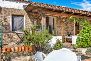a stone cottage with a table and chairs on a patio at Casettina in Loiri
