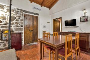 a dining room with a wooden table and a tv at Casettina in Loiri