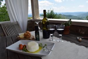 a table with a plate of food and a bottle of wine at Apartman CASA MARŠIĆ in Oprtalj