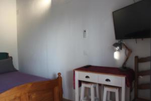 um quarto com uma cama, uma televisão e uma mesa em Mas de l'Olivier em Saint-Estève