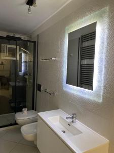 Un baño con lavabo, inodoro y espejo. en Casa Margherita - locazione turistica, en Polignano a Mare