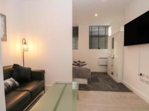 a living room with a couch and a glass table at Apartment 24 in Keighley