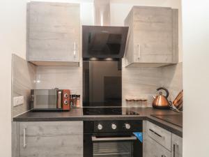 a kitchen with a microwave and a stove top oven at Apartment 24 in Keighley