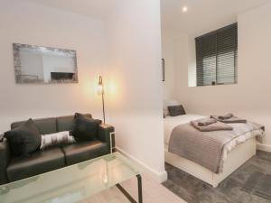 a living room with a couch and a bed at Apartment 24 in Keighley