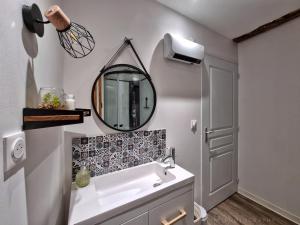 a bathroom with a sink and a mirror on the wall at Logis Sainte Claire in Montauban