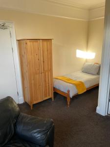 a small room with a bed and a cabinet at Winmar in Inverness