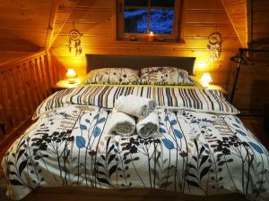 a bed in a wooden bedroom with two lamps at Vila Vilinka & Vila Native Vilinija resort Village in Podčetrtek