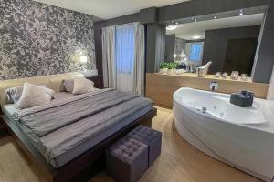 a bedroom with a bed and a bath tub at Penzion Solid Spa in Mladá Boleslav