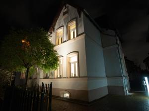 une maison blanche la nuit avec ses lumières allumées dans l'établissement EUPHORAS - Geschmackvolles Apartment in Hannover, à Hanovre