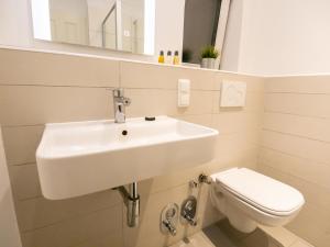 La salle de bains est pourvue d'un lavabo et de toilettes. dans l'établissement EUPHORAS - Geschmackvolles Apartment in Hannover, à Hanovre