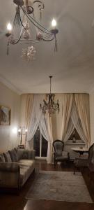 a living room with a couch and a chandelier at V.I.P.Apartmens Rynok Sqr.19 in Lviv