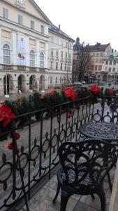 a wrought iron fence with christmas decorations on it at V.I.P.Apartmens Rynok Sqr.19 in Lviv