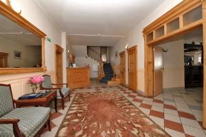 a hallway with chairs and a table and a staircase at Pensjonat Lazur in Mielno