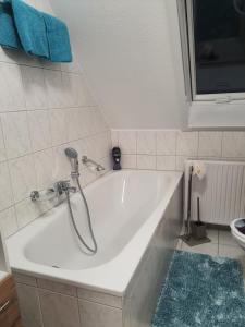 a white bath tub with a shower in a bathroom at Ferienwohnung Cziuppa in Bad Salzungen +8 photos